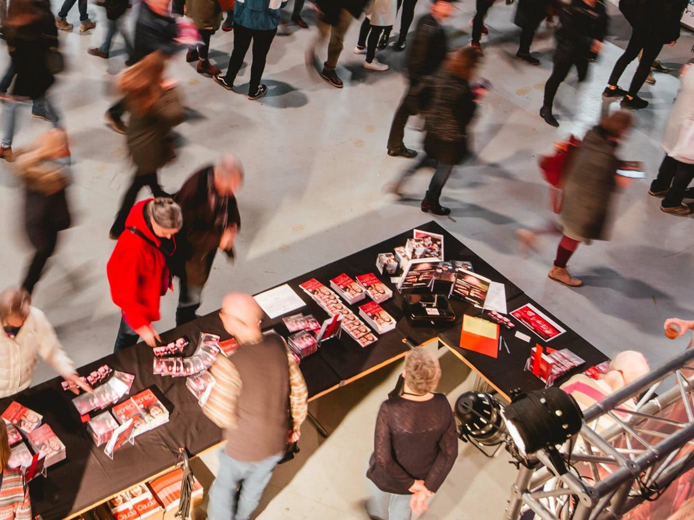 Menschen schauen sich auf einem Tisch Flyer von Life on Stage an.